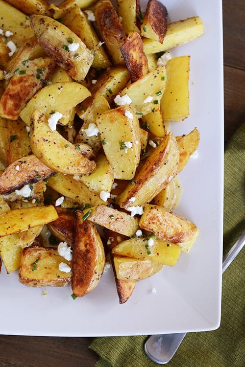 Top view of a white platter or roasted potato wedges. 