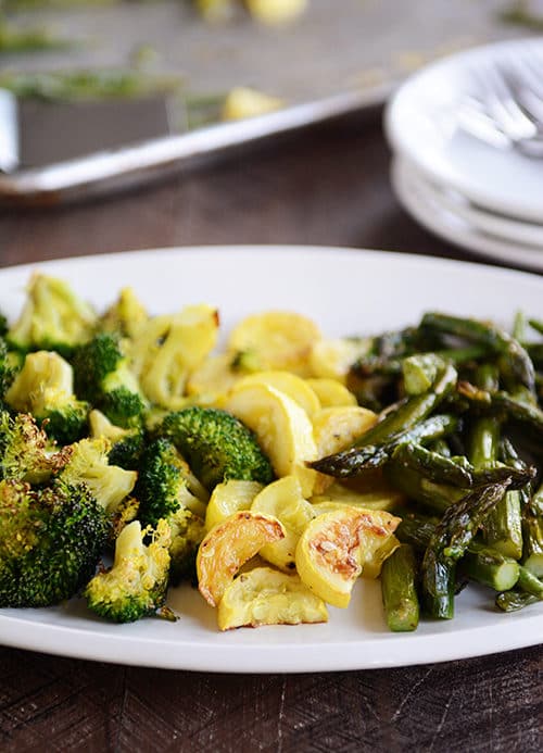 A platter of roasted broccoli, squash, and asparagus. 