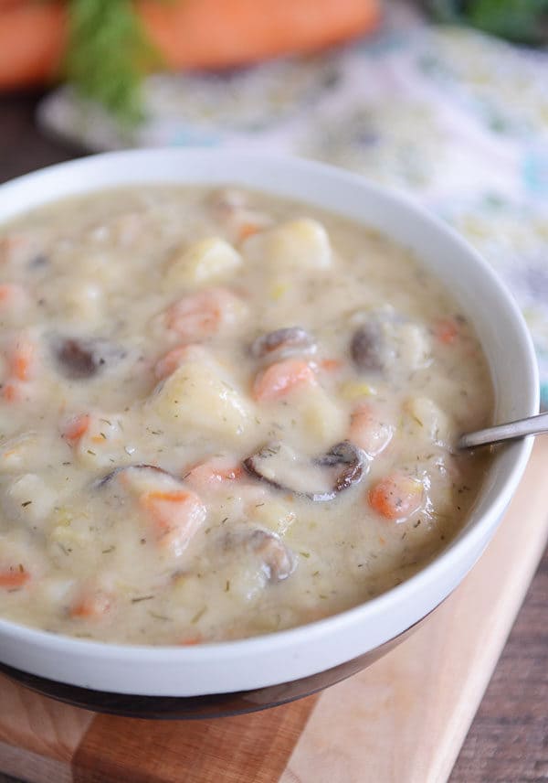 A white bowl of creamy mushroom, carrot, and potato soup.