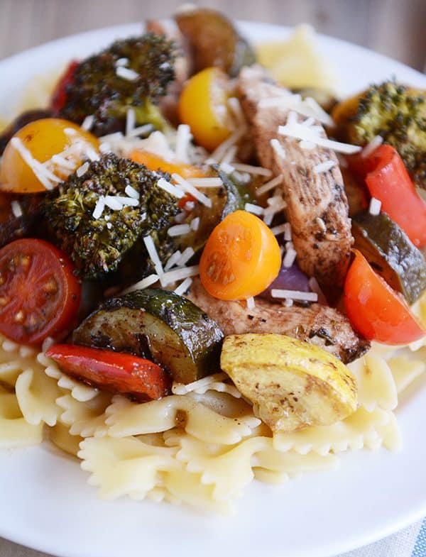 Cooked bowtie pasta topped with chicken strips and cooked veggies. 