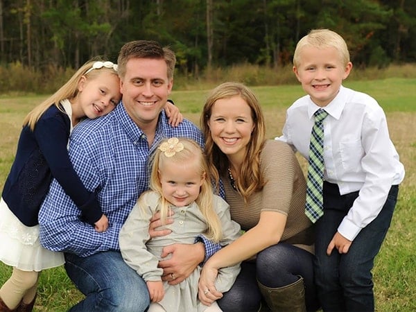 A Mom, Dad, and three small kids posing for a picture. 