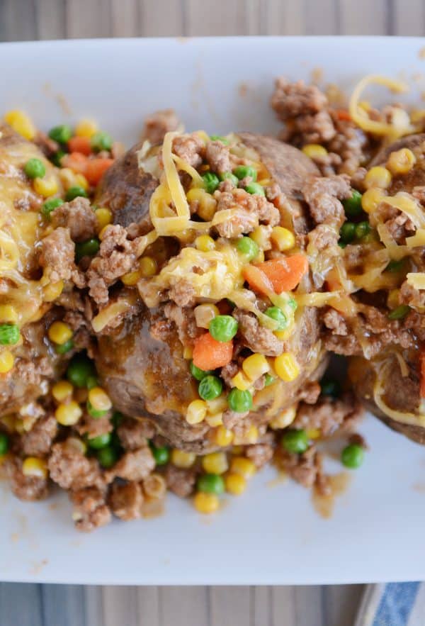 Top view of cooked baked potatoes with cooked shepherd's pie filling on top. 