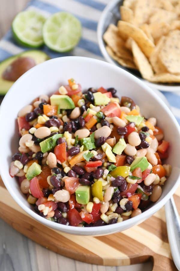 A bowl full of cowboy caviar dip in a white bowl. 