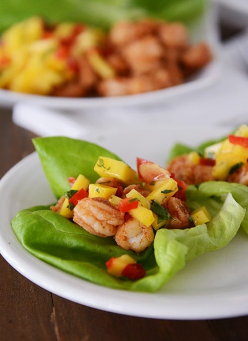 Shrimp and mango lettuce wraps on a white plate.