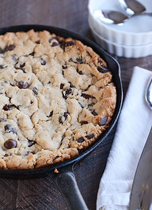 A chocolate chip cookie baked in a large skillet.