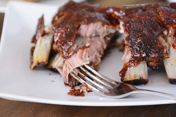 Fork taking a bite out of a rack of ribs. 