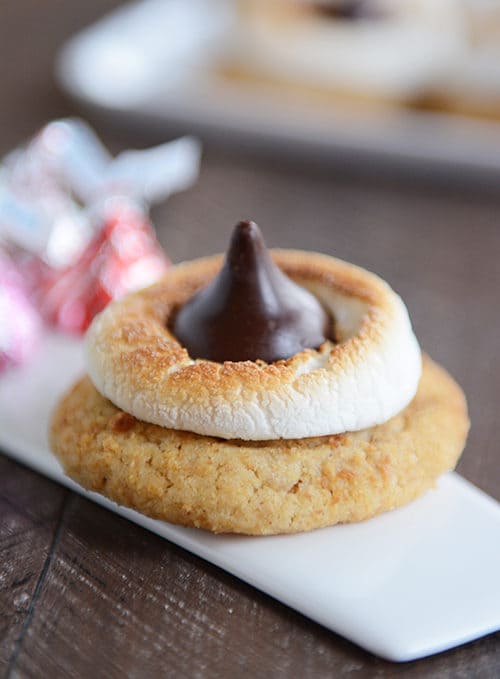 A cookie topped with a toasted marshmallow and hershey kiss. 