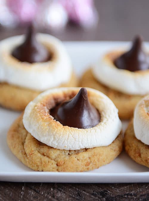A platter of cookies topped with golden brown melted marshmallows and Hershey's Kisses.