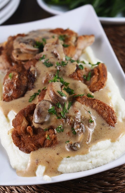 Crispy pork over creamy mashed potatoes and covered in mushroom gravy.