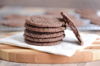 Stack of chocolate sugar cookies on a white napkin with one in half.