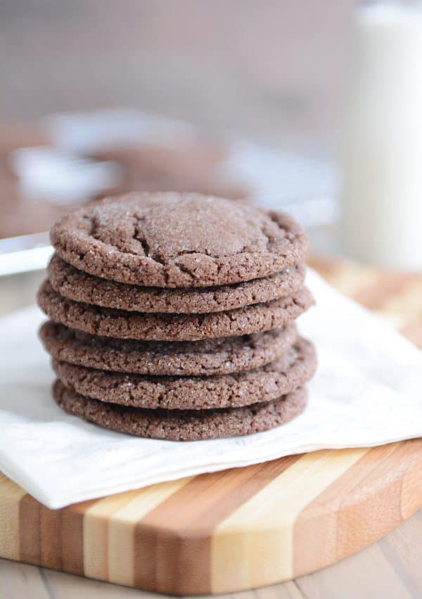 Stack of chocolate sugar cookies on white napkin.