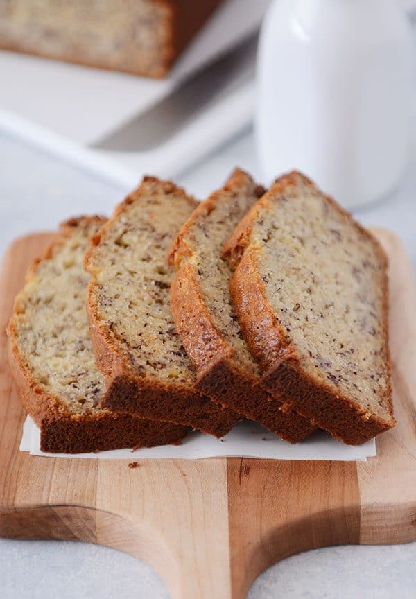 Four slices of banana bread laying on a cutting board. 