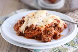 Scoop of Spaghetti squash spaghetti bake topped with cheese on a white plate.