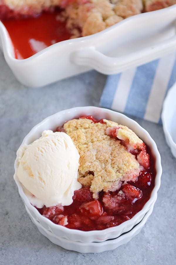 Top view of a ramekin full of strawberry cobbler and vanilla ice cream.