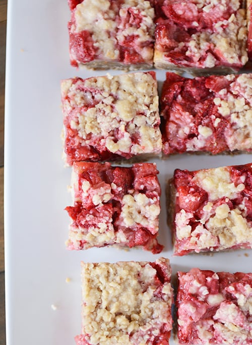 Top view of cut up strawberry shortcake bars on a white platter. 