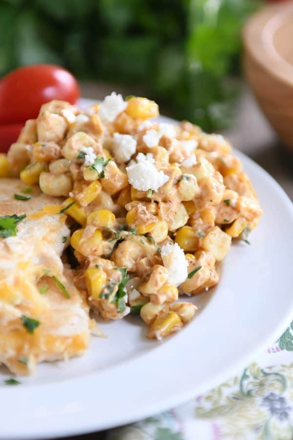 Scoop of Mexican street corn salad on white plate with quesadillas.