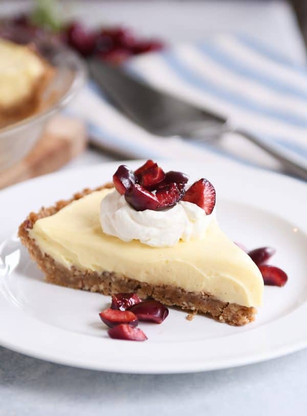 Berries and cream pie with cherries on top.