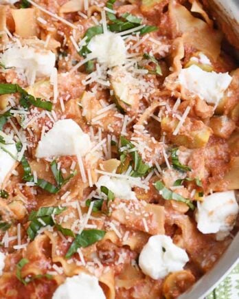 Skillet vegetable lasagna cooked in stainless skillet with dots of ricotta cheese.