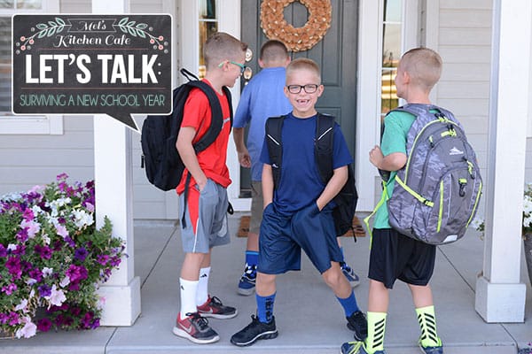 Little boys with backpacks standing on their front porch.