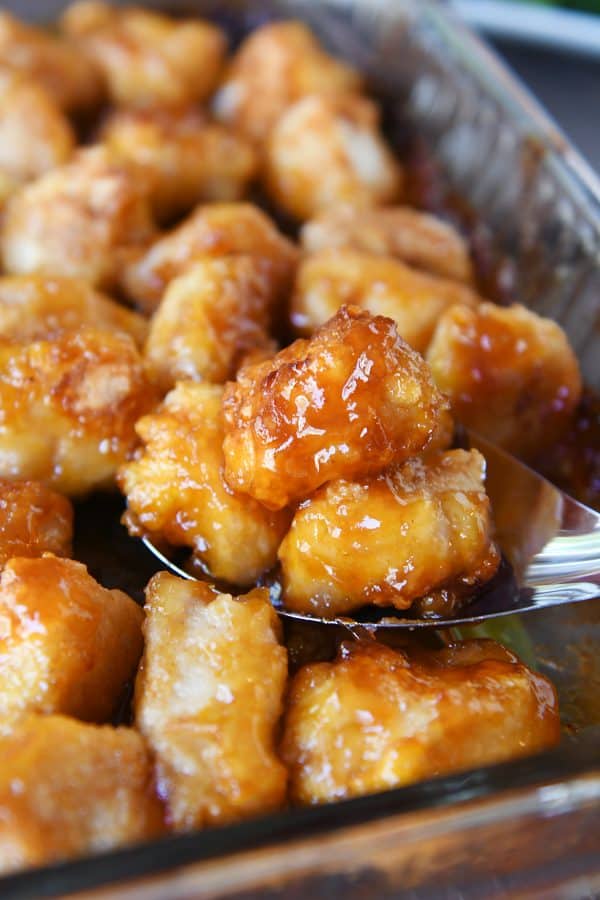Scoop of baked sweet and sour chicken from the pan.