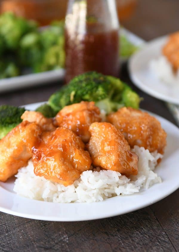 Baked sweet and sour chicken pieces over white rice with steamed broccoli.