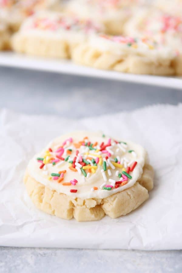 Swig sugar cookie frosted with sprinkles on white napkin.