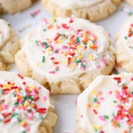 Lots of frosted Swig sugar cookies with sprinkles on white tray.