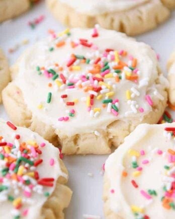 Lots of frosted Swig sugar cookies with sprinkles on white tray.