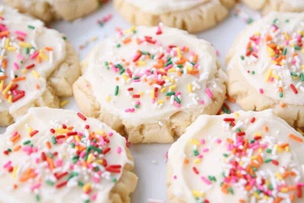 Lots of frosted Swig sugar cookies with sprinkles on white tray.