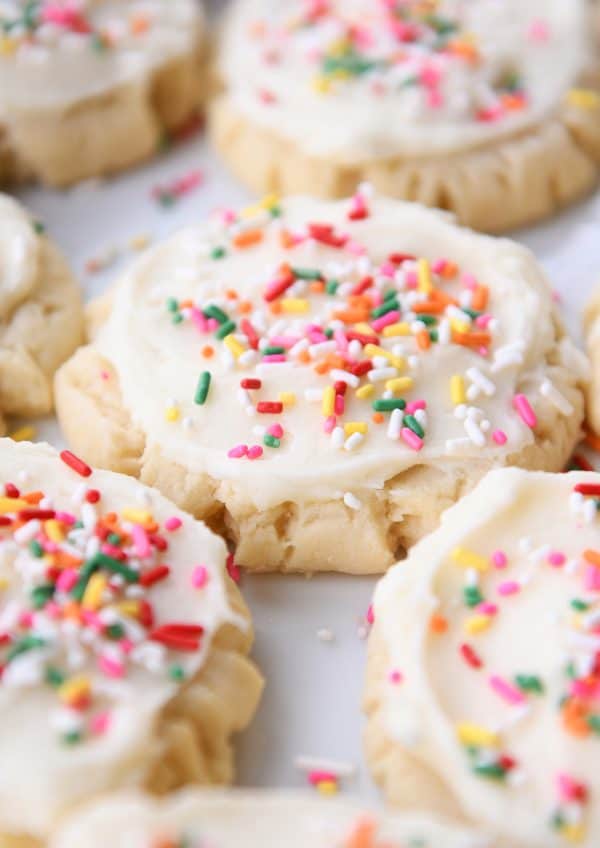 Lots of frosted Swig sugar cookies with sprinkles on white tray.