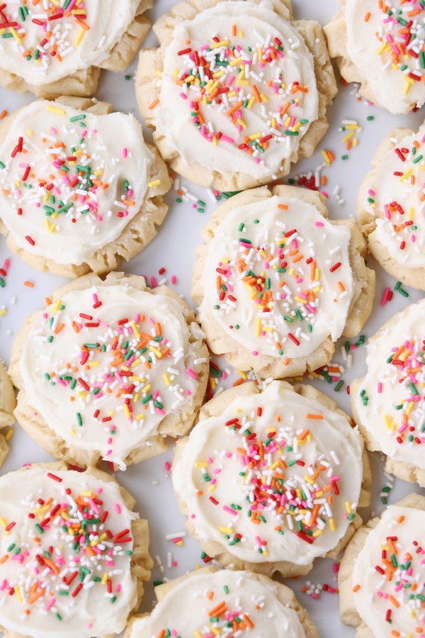 Lots of frosted Swig sugar cookies with sprinkles on white tray.