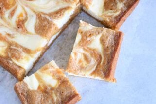 Swirled carrot cake cheesecake bars cut into squares; top down view.