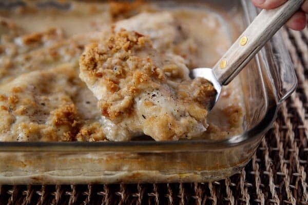 A piece of crunchy-topped swiss cheese chicken on a metal spatula. 