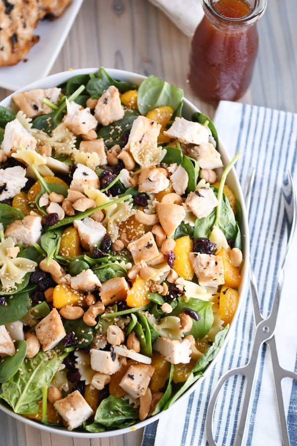 Top-down view of bowtie pasta salad with teriyaki dressing in large white bowl. 