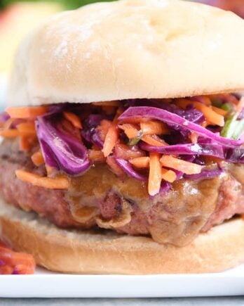 Close up of Thai burgers with peanut sauce and tangy slaw.