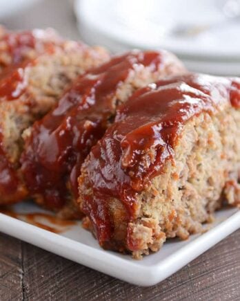 Slices of the best glazed meatloaf on white platter.