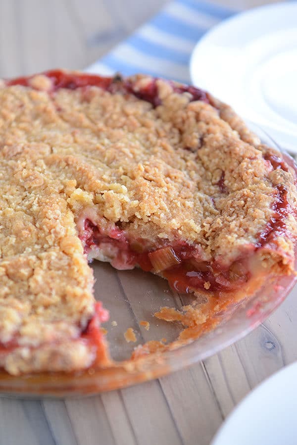 A streusel-topped, berry-filled pie in a pie plate, with one piece cut out. 