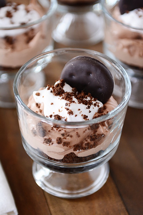 Small glass dishes full of a Thin Mint chocolate cheesecake dessert.