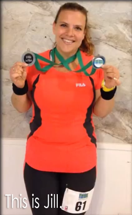 a woman holding up two running medals hung around her neck.