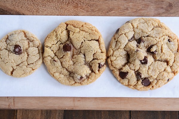 Top view of a small, medium, and large baked chocolate chip cookie.