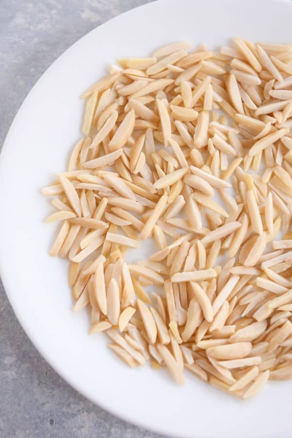 How to toast nuts in the microwave; untoasted nuts on white plate.