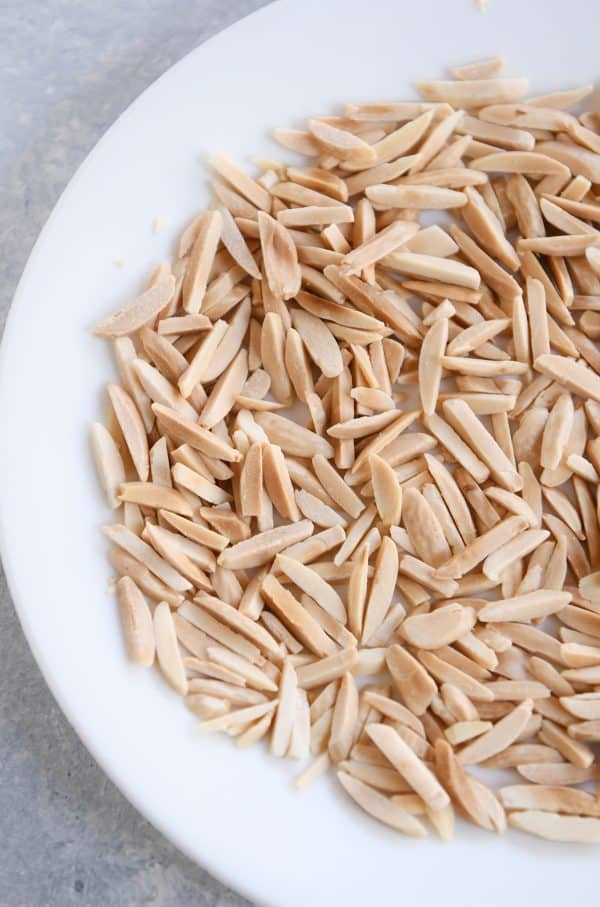 How to toast nuts in the microwave; toasted nuts on white plate.