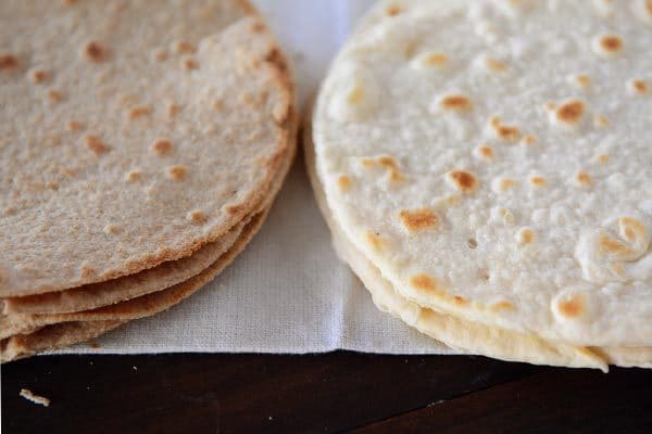 Two stacks of whole wheat and white flour homemade tortillas.