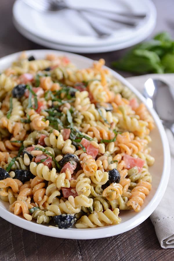 A bowl full of tri-color pasta with olives sprinkled throughout. 