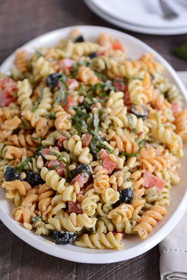 Top view of a bowl full of tri-color pasta with olives sprinkled throughout. 