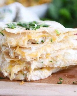 Four triangles of quesadillas stacked with cilantro on top.