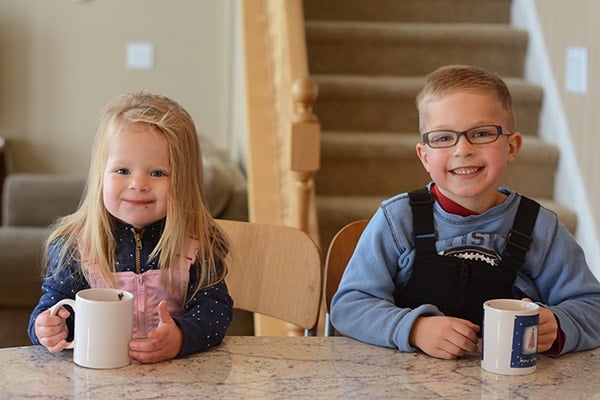 A little boy and girl drinking hot chocolate.