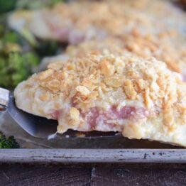 Lifting unstuffed chicken cordon bleu with spatula.