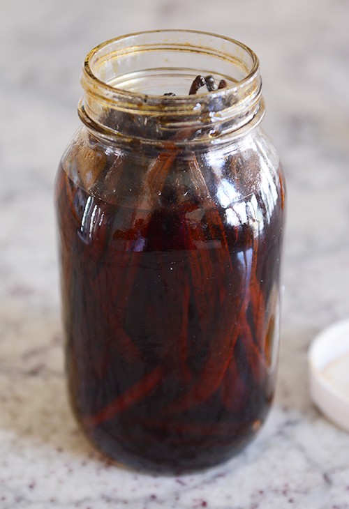 a glass mason jar filled with soaked vanilla beans