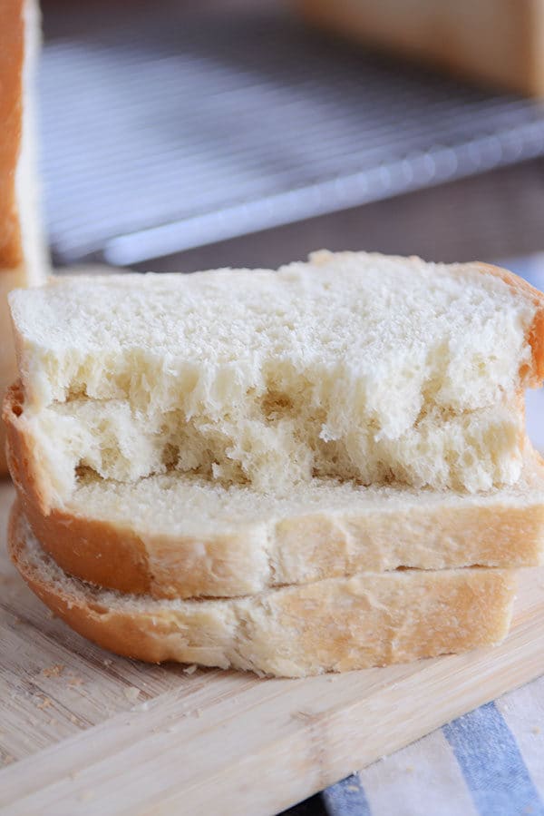 Four slices of white bread stacked on top of each other, with the top two slices ripped in half.